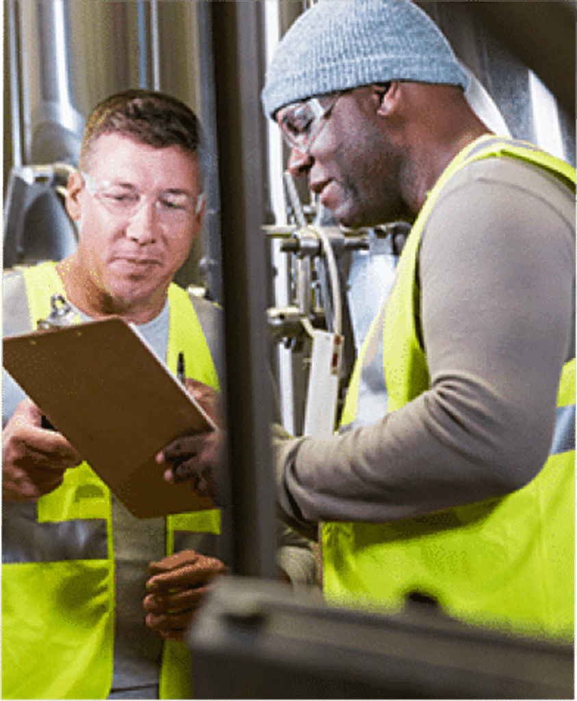 two men at a warehouse reviewing a clipboard